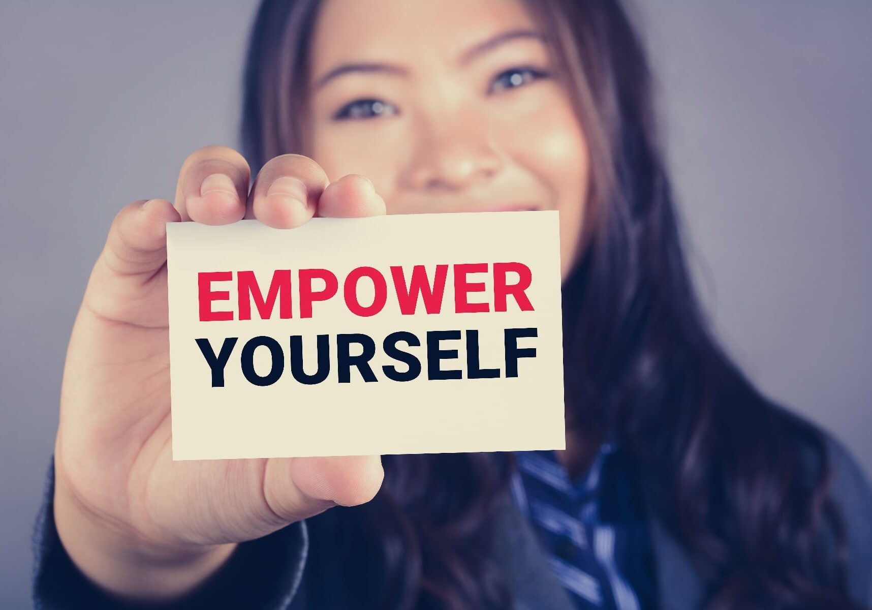 EMPOWER YOURSELF message on the card shown by a businesswoman, vintage tone effect